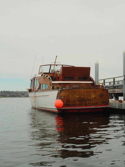 A vintage wooden boat moored on calm Seattle water