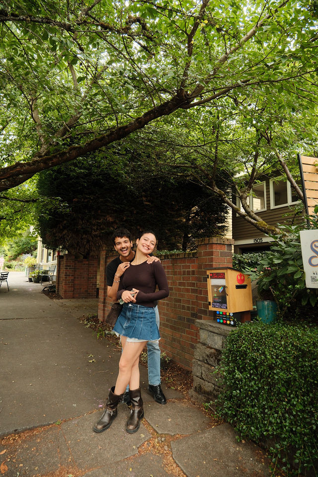 Adi and Defne standing together beneath a leafy tree