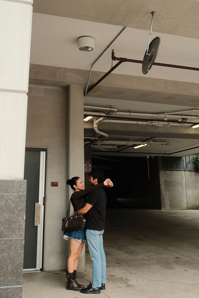 Adi and Defne embracing in a concrete passageway