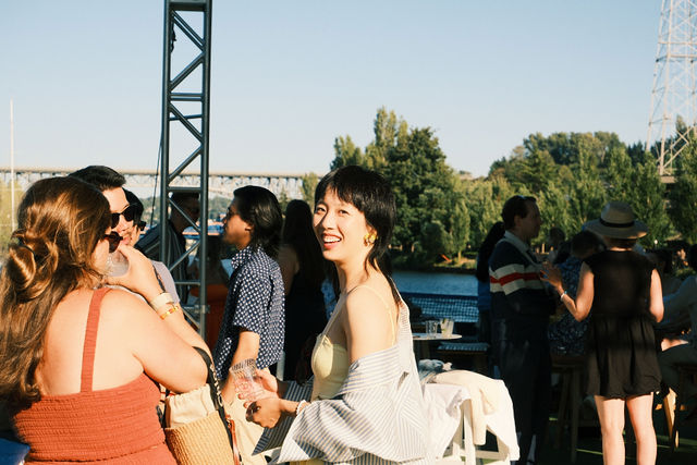 A guest laughing in warm evening light aboard a boat